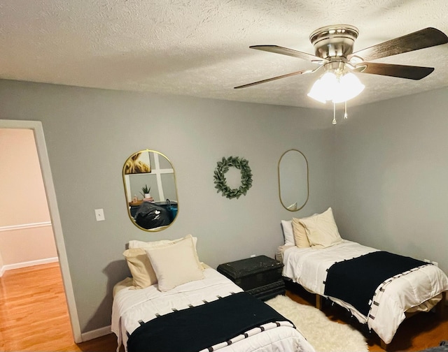 bedroom featuring a textured ceiling, ceiling fan, and light wood-type flooring