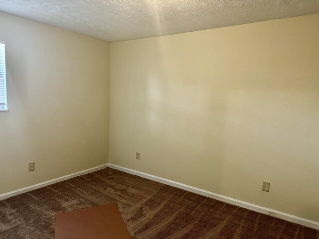 carpeted spare room with a textured ceiling