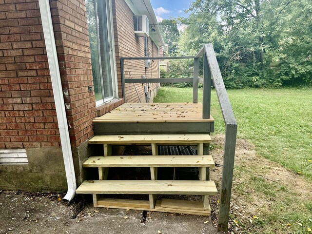 exterior space with a wall unit AC and a lawn