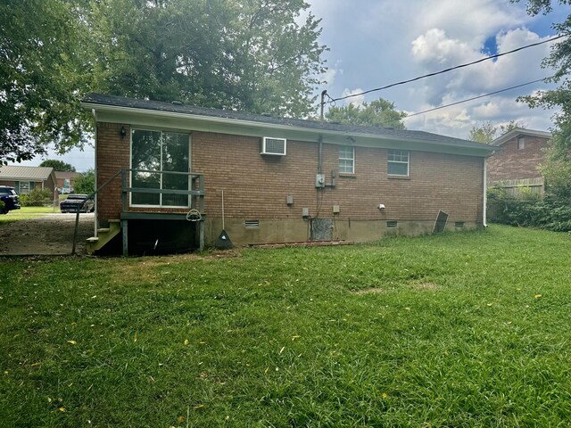 rear view of property featuring a lawn