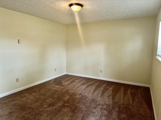 carpeted spare room with a textured ceiling