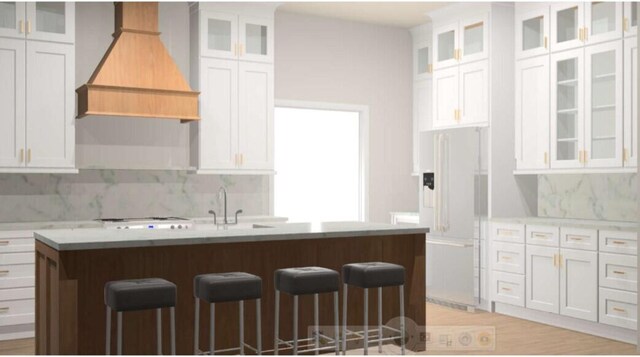 kitchen with white cabinets, a center island with sink, and white refrigerator with ice dispenser