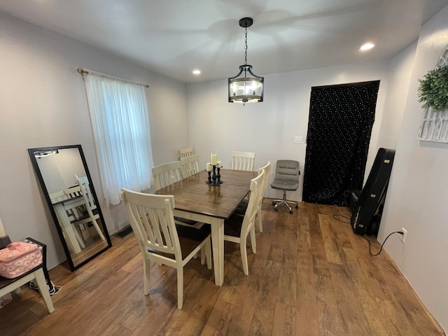 dining space with a notable chandelier and hardwood / wood-style floors