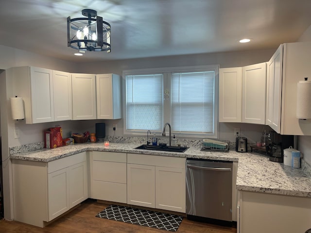 kitchen with light stone countertops, sink, white cabinetry, stainless steel dishwasher, and dark wood-type flooring