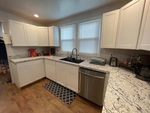 kitchen featuring sink, light wood-type flooring, white cabinetry, stainless steel dishwasher, and light stone counters