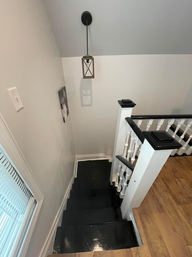 stairway with wood-type flooring and vaulted ceiling