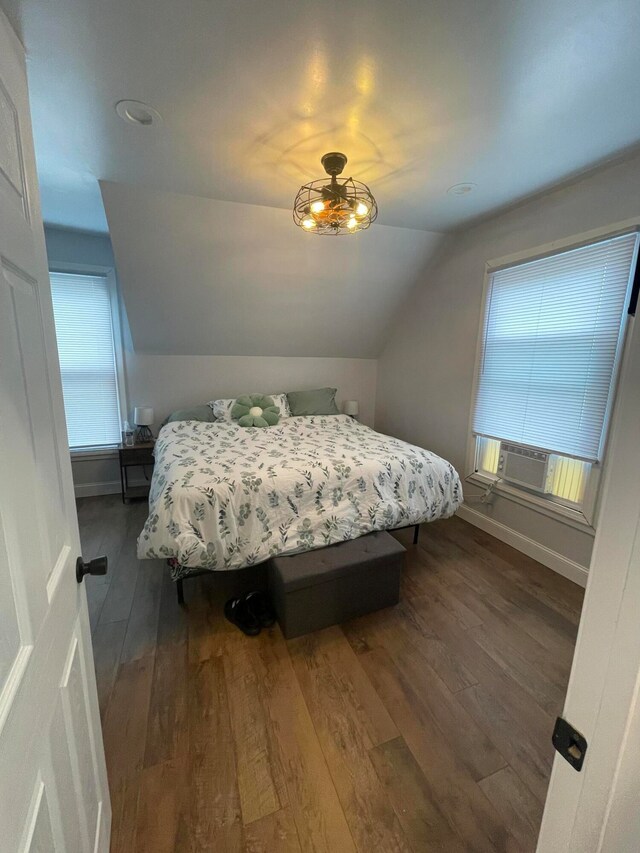 bedroom with dark wood-type flooring, cooling unit, and lofted ceiling