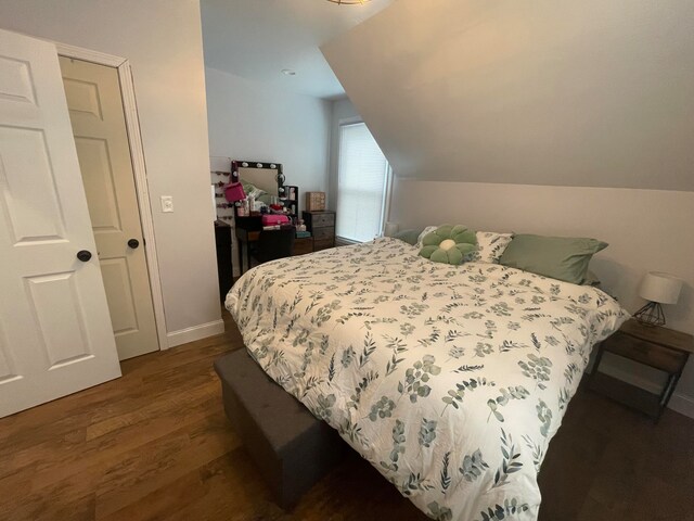 bedroom featuring dark wood-type flooring and lofted ceiling