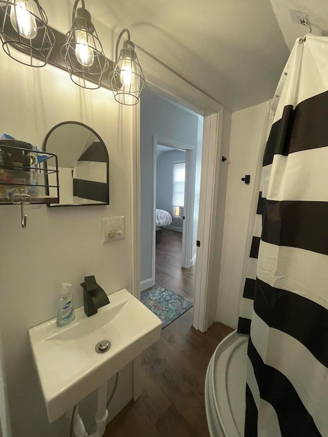 bathroom with toilet, wood-type flooring, and walk in shower