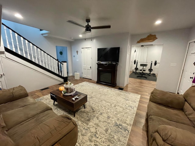 living room with ceiling fan and light wood-type flooring