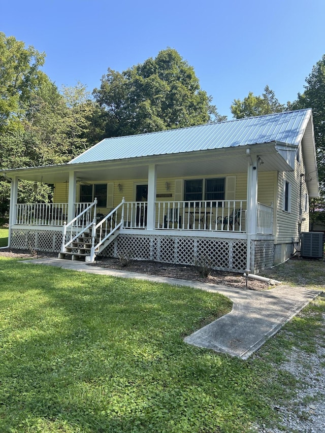 view of front facade with a porch, central air condition unit, and a front lawn
