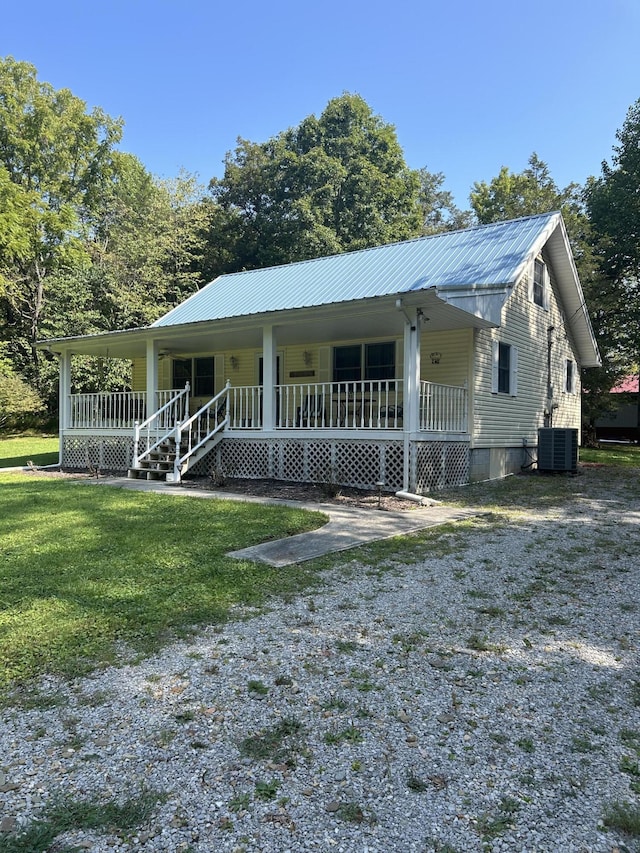 view of front of property with a porch, a front lawn, metal roof, and central air condition unit