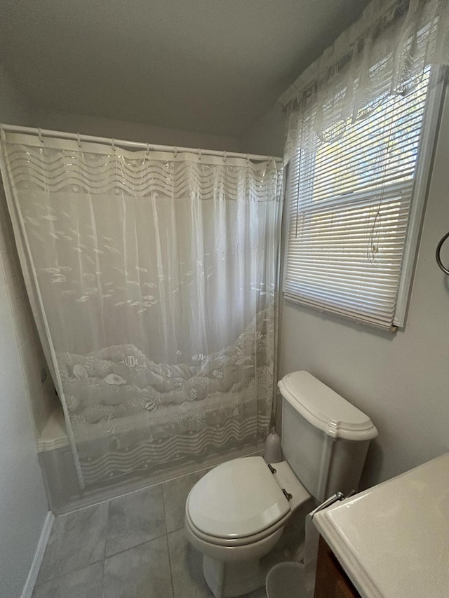 bathroom featuring toilet, tile patterned floors, vanity, and baseboards