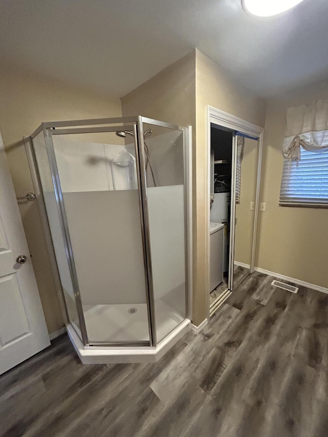 bathroom featuring a stall shower, wood finished floors, and baseboards