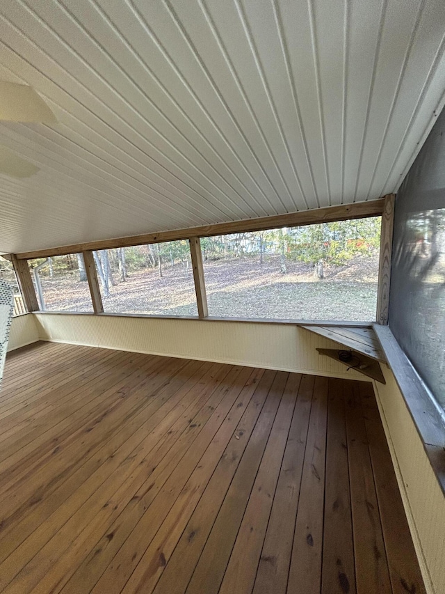 unfurnished sunroom with healthy amount of natural light, hardwood / wood-style flooring, and wood ceiling