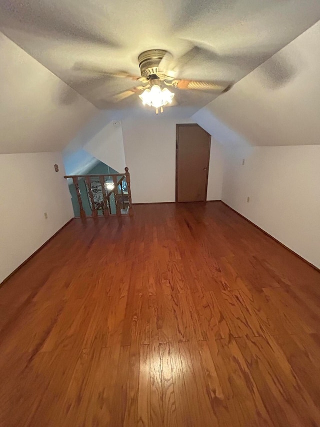 bonus room featuring lofted ceiling, a textured ceiling, wood-type flooring, and ceiling fan