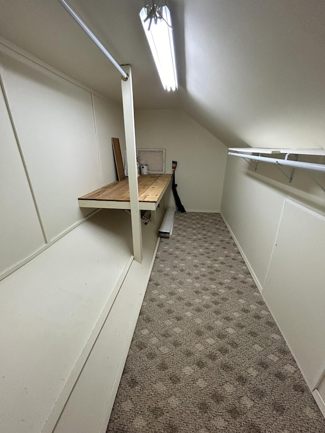 walk in closet with carpet floors and vaulted ceiling