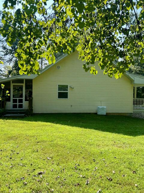 view of property exterior featuring a yard and a sunroom