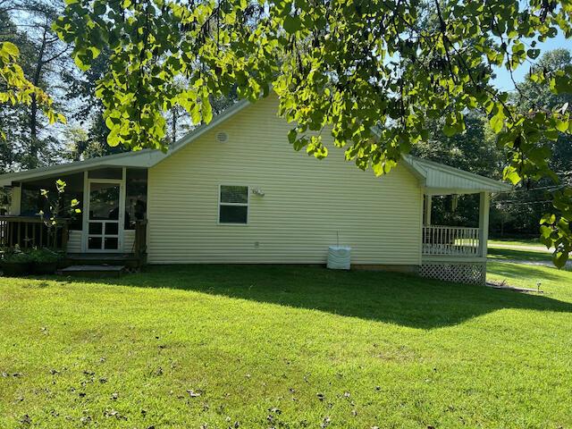 view of property exterior featuring a lawn and a sunroom