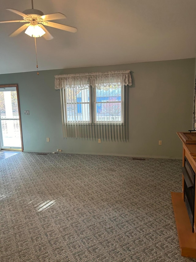 unfurnished living room with carpet floors and ceiling fan