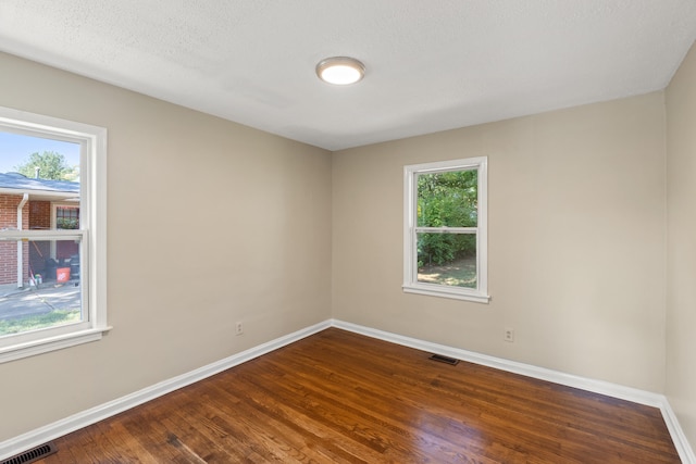 unfurnished room featuring plenty of natural light, baseboards, and visible vents