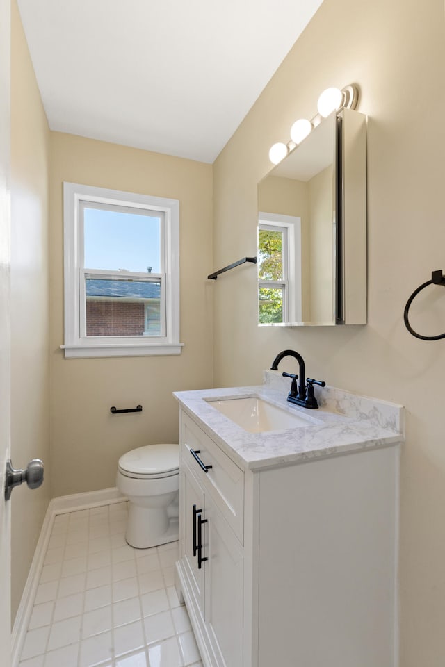 bathroom featuring toilet, baseboards, and vanity