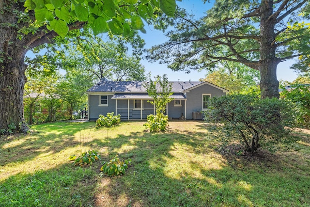 back of house with a sunroom, a lawn, and central air condition unit