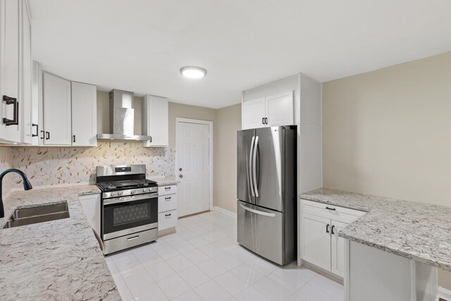 kitchen with wall chimney exhaust hood, backsplash, appliances with stainless steel finishes, sink, and white cabinetry