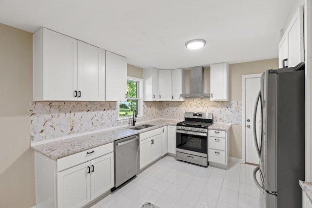 kitchen featuring wall chimney exhaust hood, appliances with stainless steel finishes, backsplash, and a sink