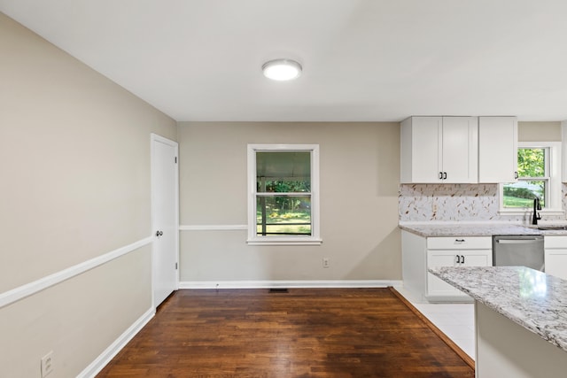 kitchen with baseboards, tasteful backsplash, light stone counters, and dishwasher