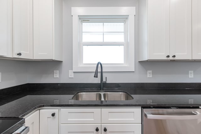 kitchen with stainless steel appliances, dark stone counters, sink, and white cabinetry