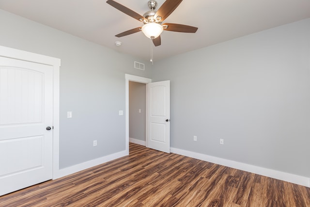 unfurnished bedroom with ceiling fan and dark hardwood / wood-style floors