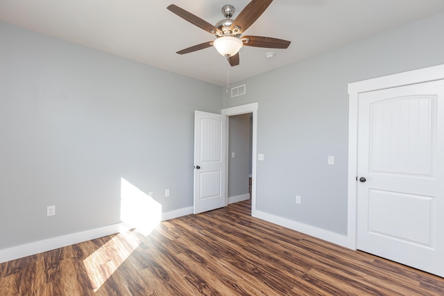 unfurnished bedroom featuring ceiling fan and dark hardwood / wood-style flooring