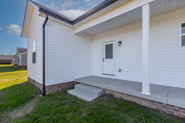 entrance to property featuring a lawn