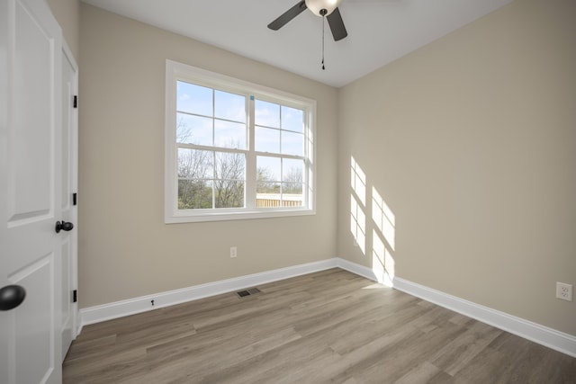 spare room with ceiling fan and light wood-type flooring