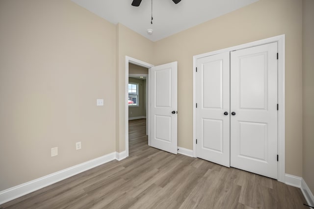 unfurnished bedroom featuring ceiling fan, a closet, and light hardwood / wood-style flooring