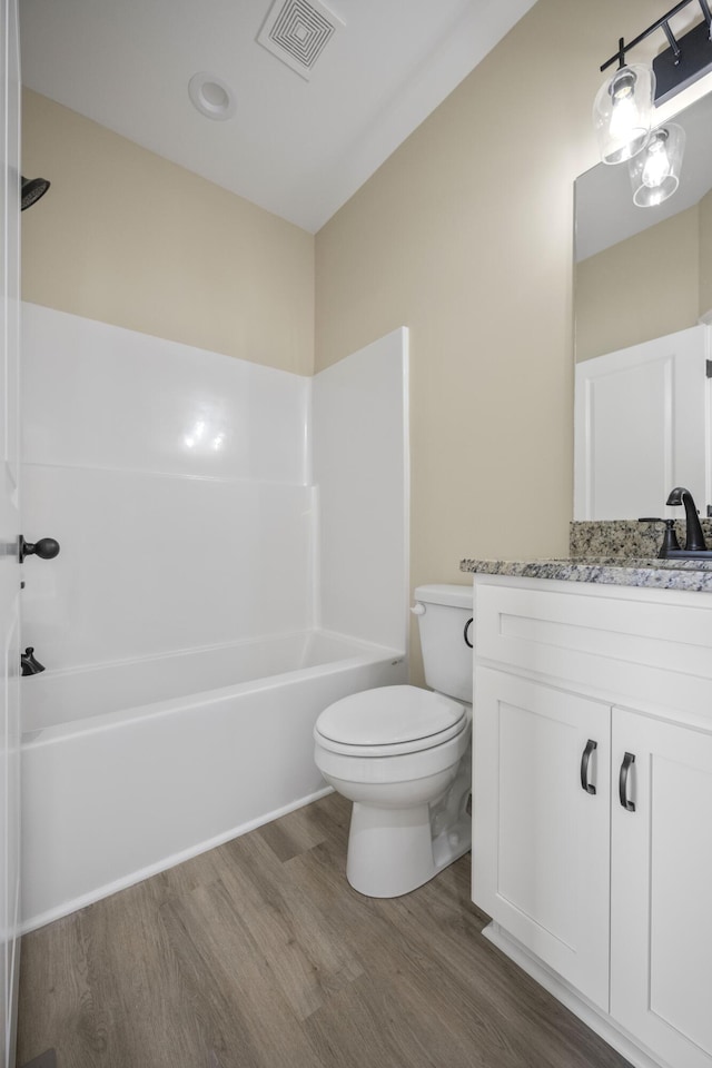 full bathroom featuring vanity, wood-type flooring, shower / bathtub combination, and toilet