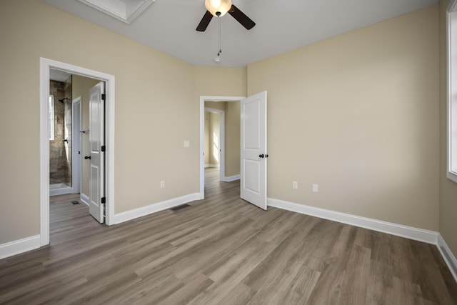 unfurnished bedroom with light wood-type flooring, ensuite bath, and ceiling fan