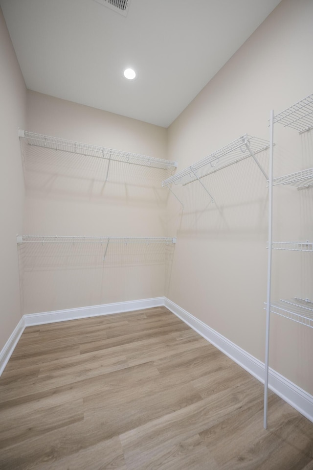 walk in closet with hardwood / wood-style floors