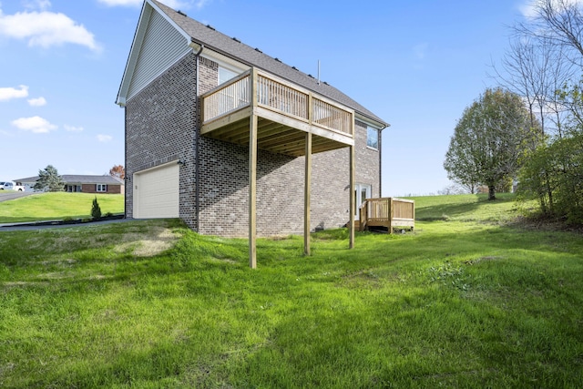 view of side of property featuring a wooden deck, a yard, and a garage