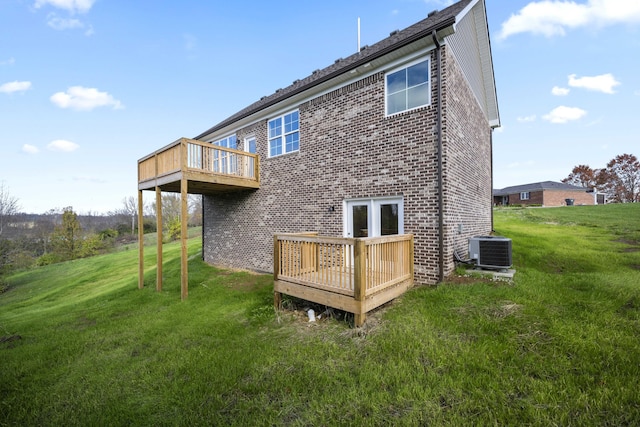 rear view of property with a lawn, central AC unit, and a deck