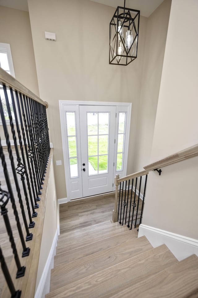 foyer entrance with light hardwood / wood-style flooring and a notable chandelier