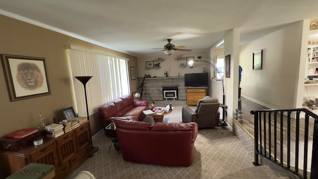 living room with ceiling fan, carpet floors, a fireplace, and ornamental molding