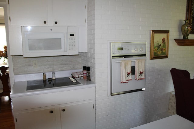 kitchen featuring white cabinetry, tile walls, white appliances, and backsplash