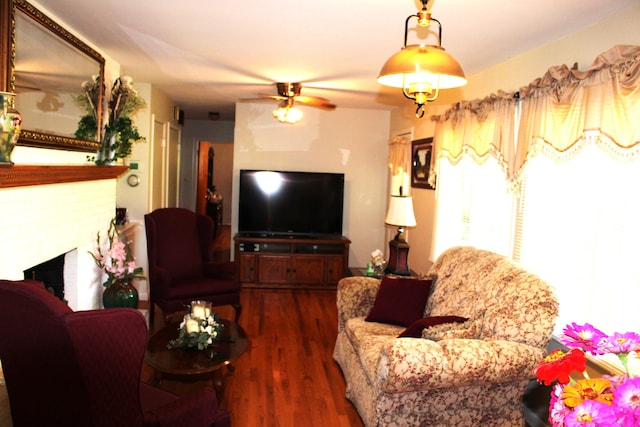 living room featuring a fireplace, dark wood-type flooring, and ceiling fan