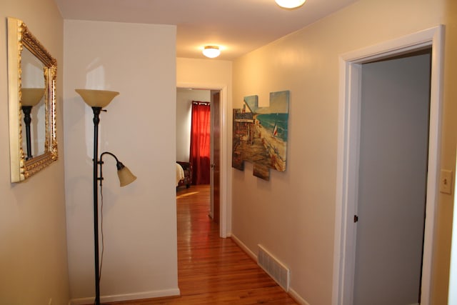 corridor with hardwood / wood-style flooring