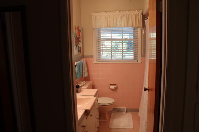 bathroom with vanity, toilet, tile walls, and a shower with shower curtain