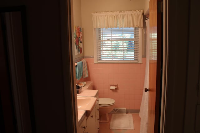 full bath featuring toilet, vanity, visible vents, tile walls, and tile patterned floors