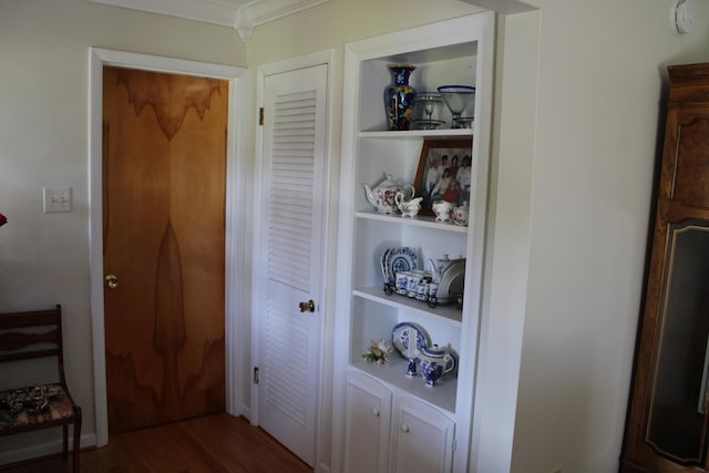 room details featuring built in features, crown molding, and wood finished floors