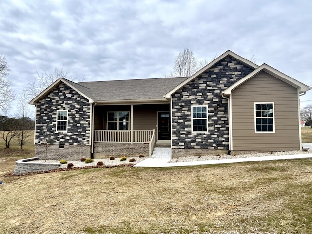 ranch-style home featuring covered porch and a front lawn